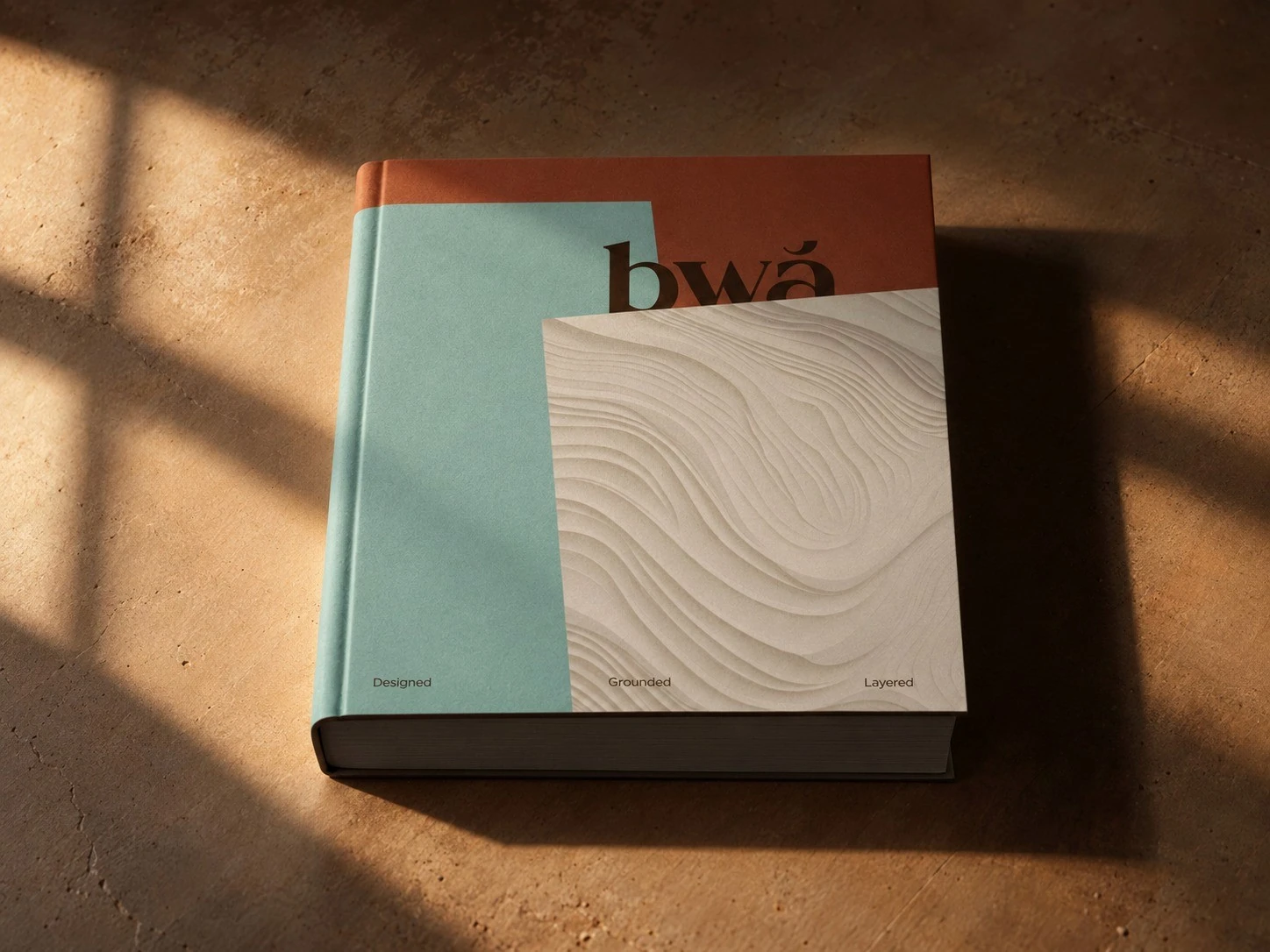 BWĀ booklets with mint and cream covers in afternoon light