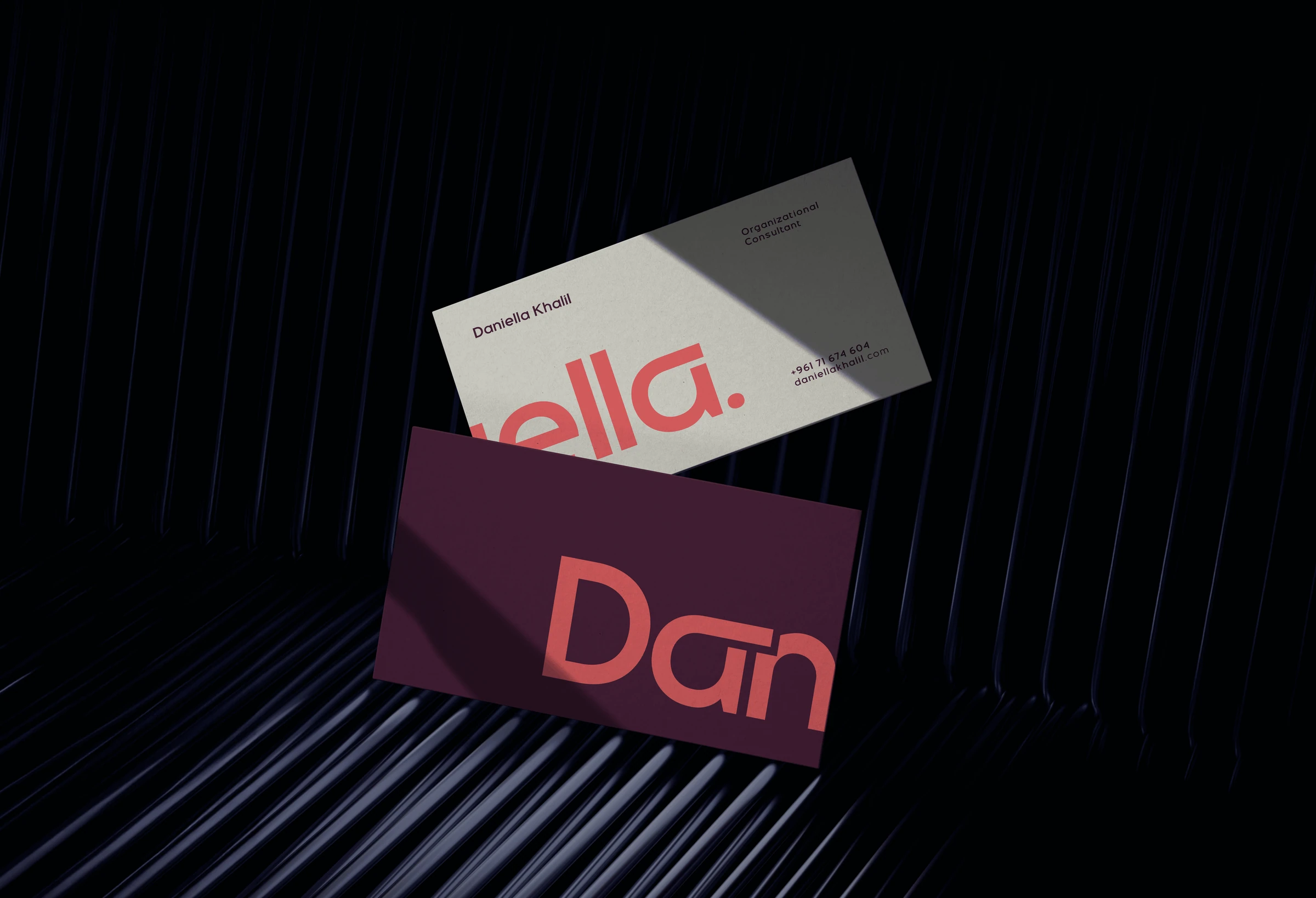 Pink and burgundy Daniella Khalil wordmark across stacked business cards