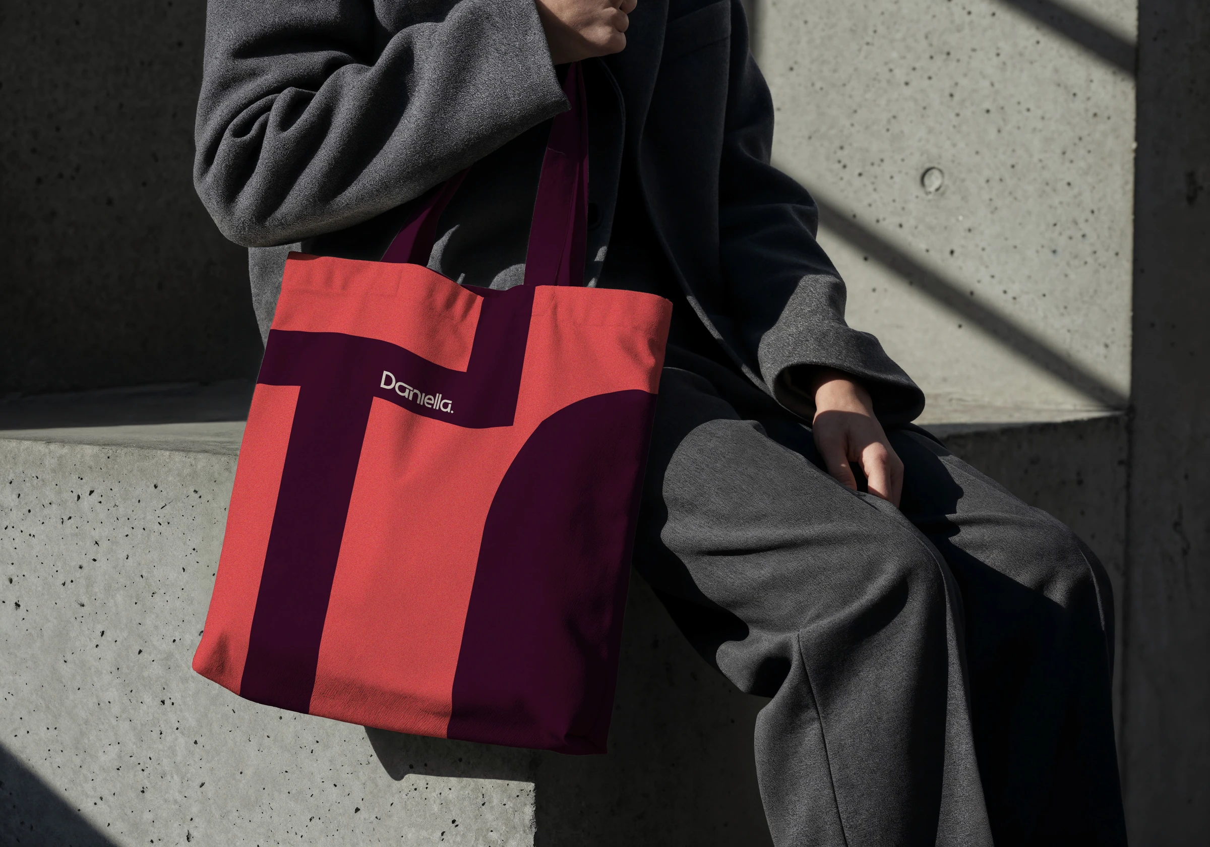 Burgundy Daniella Khalil tote bag carried by a person in dark clothing